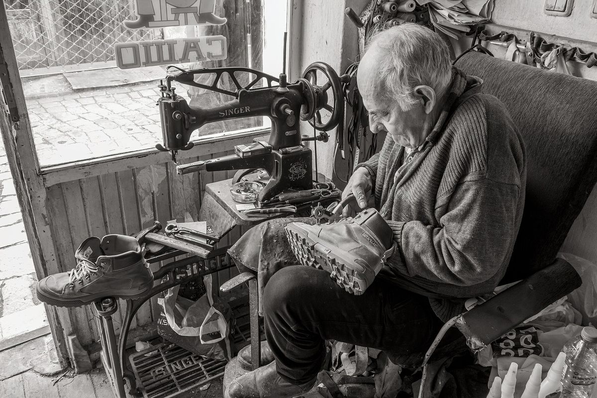 Cobbler repairing shoes in old workshop